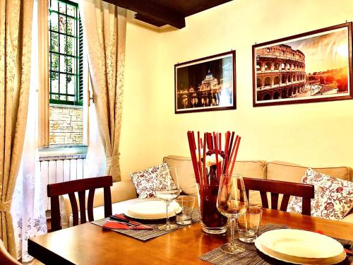 a dining room table with plates and wine glasses at La Tana al Flaminio in Rome