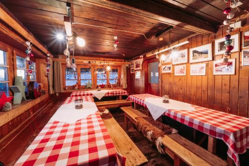 a restaurant with two tables and a red and white checkered table cloth at Obere Maxlraineralm in Spitzingsee