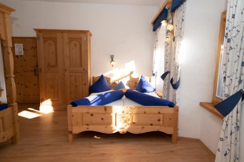 a bedroom with a bed with blue pillows on it at Crusch Alba Studio auf der Strassenseite Sta Maria in Sta Maria Val Müstair