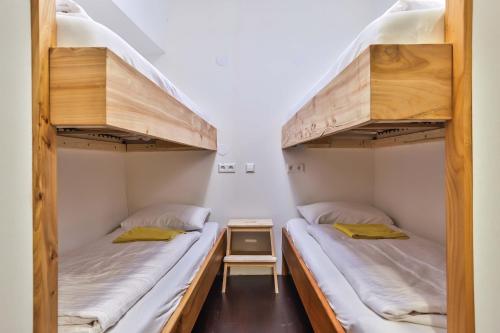 two bunk beds in a room with a table at Hotelschip Bracksand Amsterdam City, in de zomer én de winter! in Amsterdam