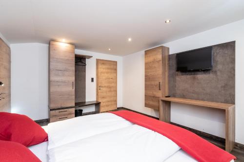 a bedroom with a large bed with a flat screen tv at Bergappartements Pröll in Kleinarl