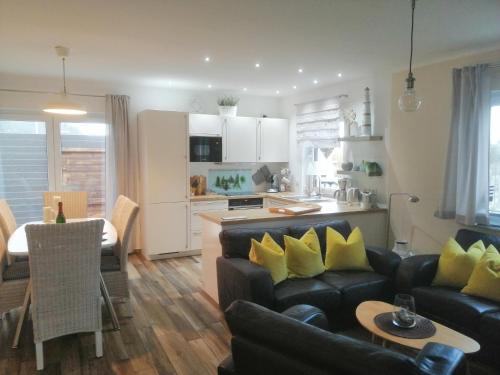 a living room with a couch and a table and a kitchen at Haus Ostwind in Zinnowitz