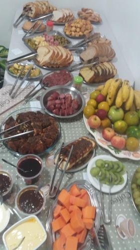 stół z wieloma różnymi rodzajami żywności w obiekcie Hotel Pousada Rolantchê w mieście Rolante
