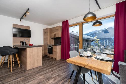 una cucina e una sala da pranzo con tavolo e vista di Bergappartements Pröll a Kleinarl