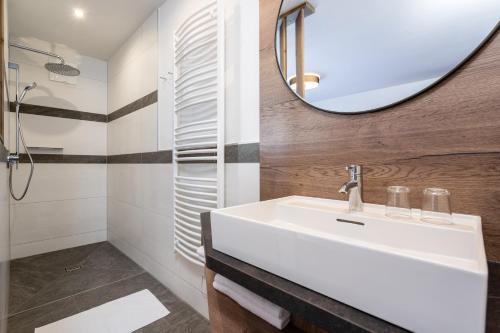 a bathroom with a white sink and a mirror at Bergappartements Pröll in Kleinarl
