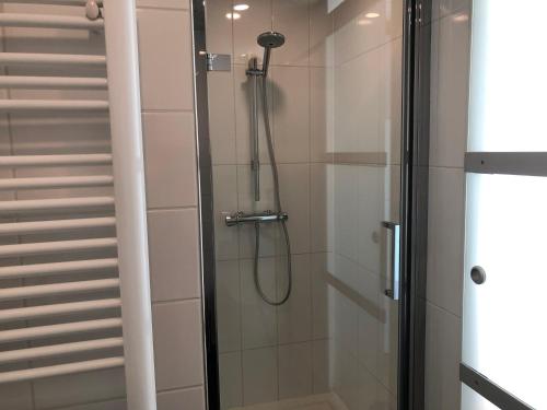 W łazience znajduje się prysznic ze szklanymi drzwiami. w obiekcie B&B De nieuwendijk w mieście Zuid-Beijerland