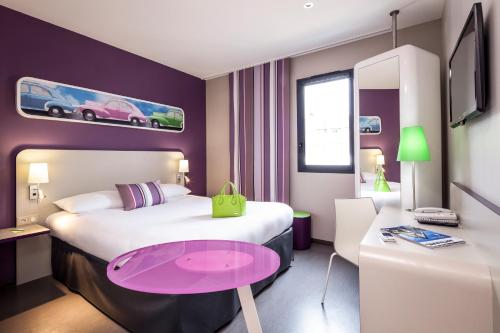 
a hotel room with a bed and a desk at ibis Styles Montbéliard in Montbéliard
