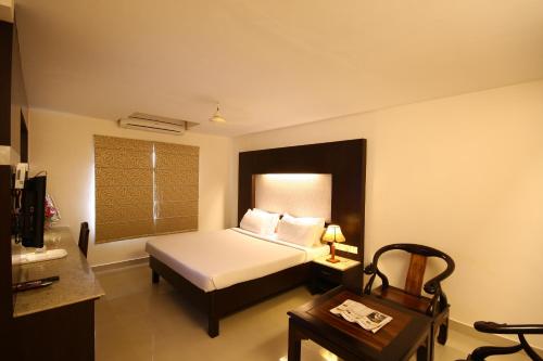 a bedroom with a bed and a table with a table sidx sidx sidx at Hotel Crescent Crest Sriperumbudur in Sriperumbudur