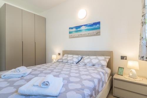 een slaapkamer met een bed met handdoeken erop bij Apartment Sant Agata-6 - Tremezzina in Ossuccio