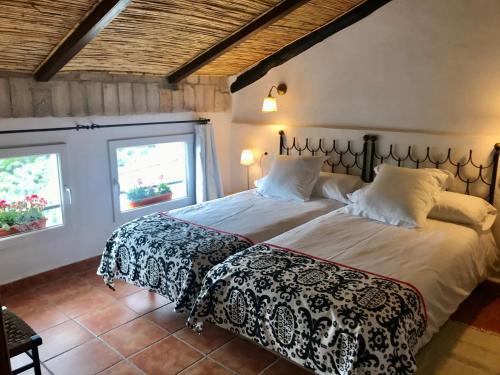 a bedroom with two beds and two windows at al-qandil in Margarida