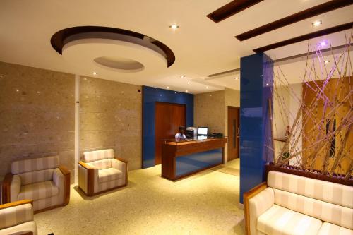 un vestíbulo con sillas y una persona sentada en un escritorio en Hotel Crescent Crest Sriperumbudur, en Sriperumbudur