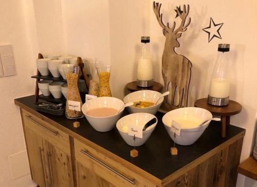 a wooden cabinet with bowls and candles on it at Hotel ZUM STERNENHOF in Kössen