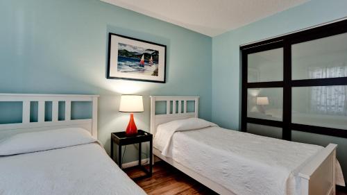 two beds in a bedroom with blue walls and a window at Shorewalk Vacation Villa in Bradenton