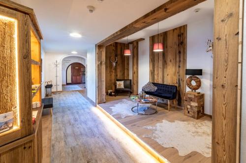 a living room with wood paneled walls and a hallway at Hotel ZUM STERNENHOF in Kössen