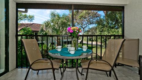 a table with a vase of flowers on a balcony at Shorewalk Vacation Villa in Bradenton
