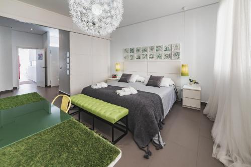 a bedroom with a large bed and a chandelier at Beach & Urban Attic in Alicante