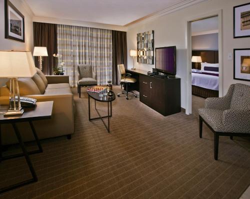 a hotel room with a couch and a bed and a television at Crowne Plaza Suffern-Mahwah, an IHG Hotel in Suffern