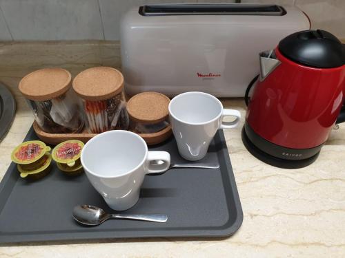 a tray with cups and spoons next to a toaster at Millan Astray in Ceuta