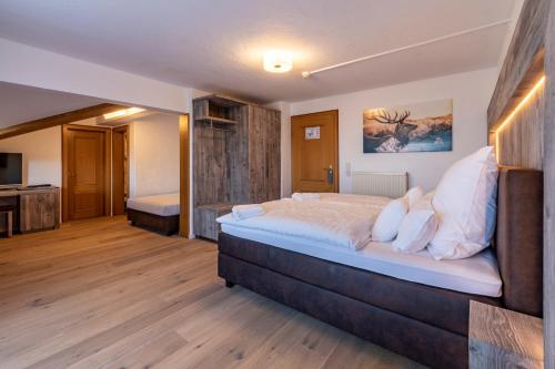 um quarto com uma cama grande num quarto em Hotel ZUM STERNENHOF em Kössen