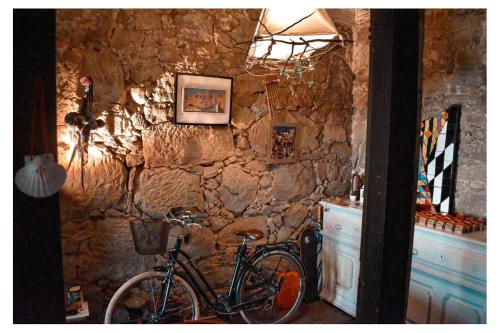 una bicicleta está estacionada contra una pared de piedra en Dans L'Atelier Hostel en Braga
