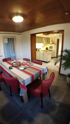 une salle à manger avec une table et des chaises rouges dans l'établissement Maison des écluses Strasbourg F3 90m2 Jacuzzi Climatisation, à Strasbourg