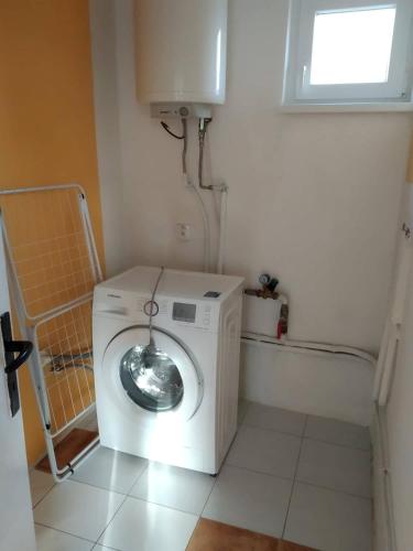 a washer and dryer in a room with a window at Apartmán Karolína in Láb