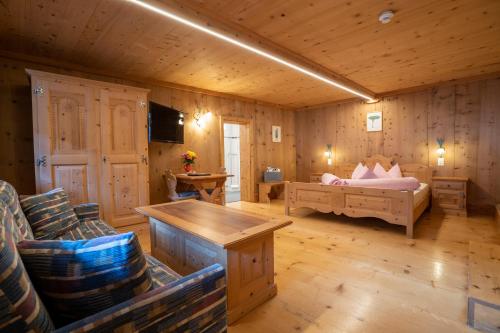 a room with a bedroom with a bed and a couch at Hotel Crusch Alba Sta Maria in Sta Maria Val Müstair