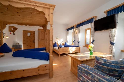 a bedroom with two beds and a living room at Hotel Crusch Alba Sta Maria in Sta Maria Val Müstair