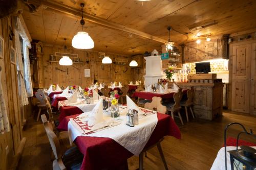 a dining room with tables with red and white table settings at Hotel Crusch Alba Sta Maria in Sta Maria Val Müstair