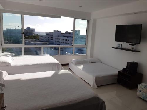 a hotel room with two beds and a flat screen tv at Edificio Bahia Fragata Apartamento Loft 806 in San Andrés