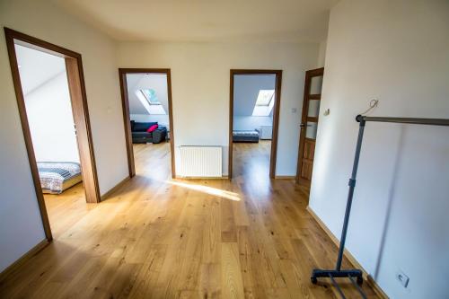 an empty room with three doors and a hard wood floor at Dom w lesie in Łask