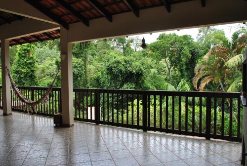 a porch with a black fence and a hammock at Grey House in Foz do Iguaçu