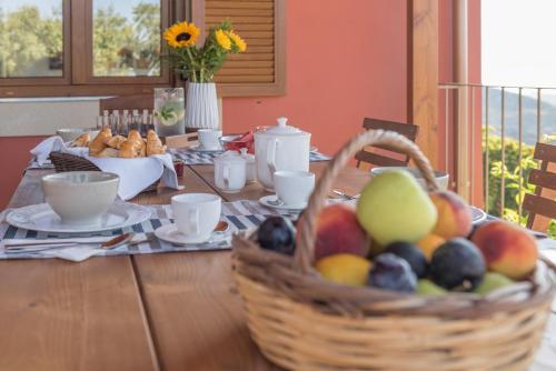 a wooden table with a basket of fruit on it at ONOMY Country House Vathypetro in Archanes
