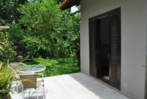 a patio with a table and chairs and a door at Grey House in Foz do Iguaçu