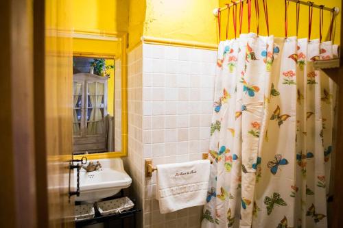 a bathroom with a shower curtain with butterflies on it at Lo Racó de Peret in Camarles