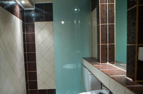 two pictures of a bathroom with a shower and a sink at Exohiko in Palaios Agios Athanasios