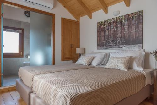 a bedroom with a large bed with a painting on the wall at ONOMY Country House Vathypetro in Archanes