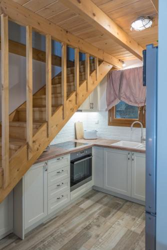 a kitchen with white cabinets and wooden stairs at ONOMY Country House Vathypetro in Archanes