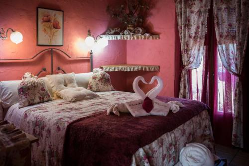 a bedroom with a bed with a pink wall at Lo Racó de Peret in Camarles