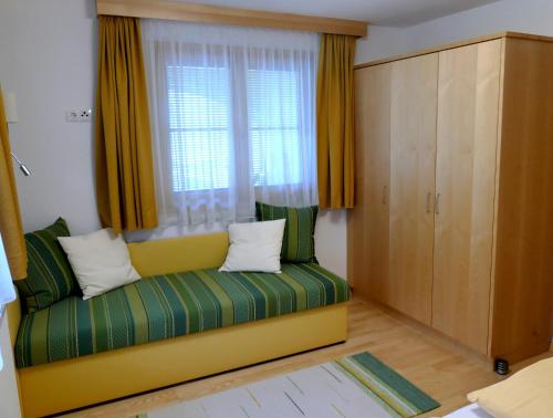 a room with a green couch and a window at Haus Lundegg in Finkenberg