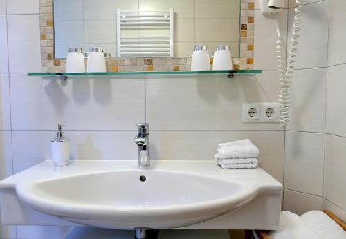 a bathroom with a sink and a mirror and towels at Haus Lundegg in Finkenberg