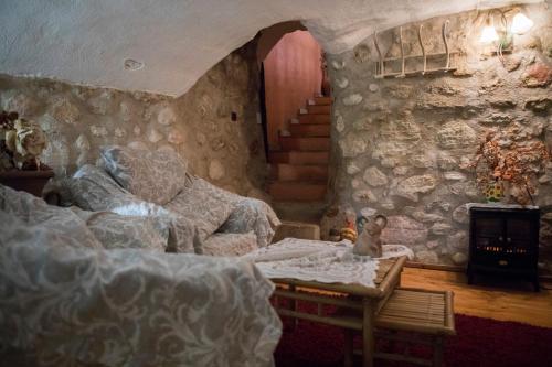 a bedroom with a bed and a stone wall at Lo Racó de Peret in Camarles