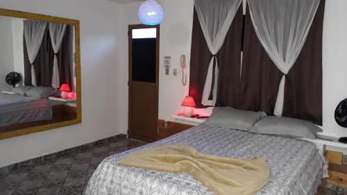 um quarto com uma cama com um cobertor em Pousada São Pedro em Lambari