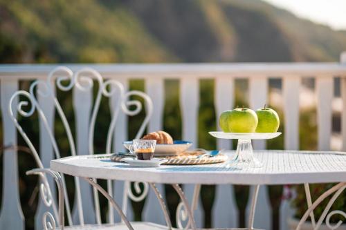 a white table with apples and bread on it at Eneide in Palmi
