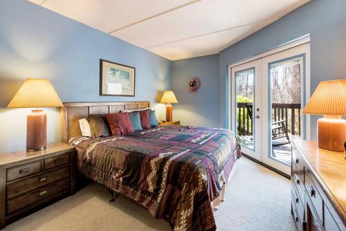 a bedroom with a bed and a desk with two lamps at Two bedroom mountain condo, 2 minutes from ski resort, pool and clubhouse onsite ! in Gatlinburg