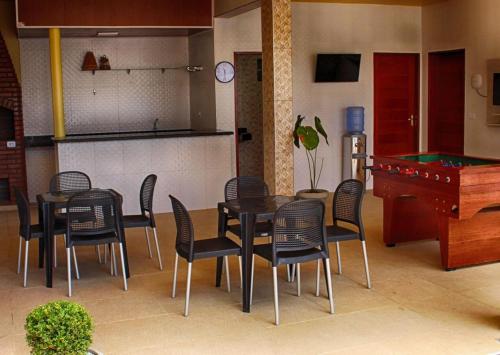 a dining room with a table and chairs and a piano at FLAT RIOMAR in Coruripe