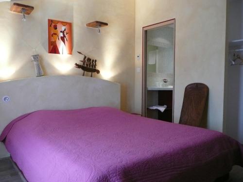 A bed or beds in a room at Hotel Le Mas de Rivet