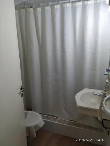 a bathroom with a shower curtain and a sink at Hotel de Campo in Concordia