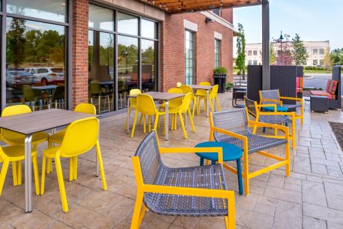 a patio with tables and chairs and windows at Home2 Suites By Hilton Columbus/West, OH in Columbus