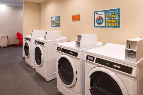 a laundry room with three washing machines in it at Home2 Suites By Hilton Columbus/West, OH in Columbus